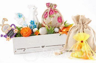 Barevné velikonoční kompozice z látkových sáčků a obdélníkového květináče s velikonoční vajíčkami.