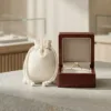 Přírodní bavlněný sáček vedle elegantní krabičky se zásnubním prstenem.