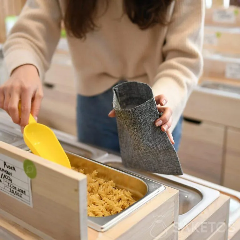 Žena nakupuje tak, že dává volně ložené produkty do trvanlivých nákupních pytlů - opakovaně použitelných jutových obalů.